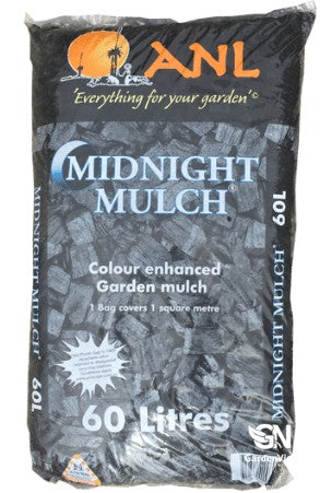 Black organic mulch spread around garden plants in a landscaped bed showing rich dark texture and coverage