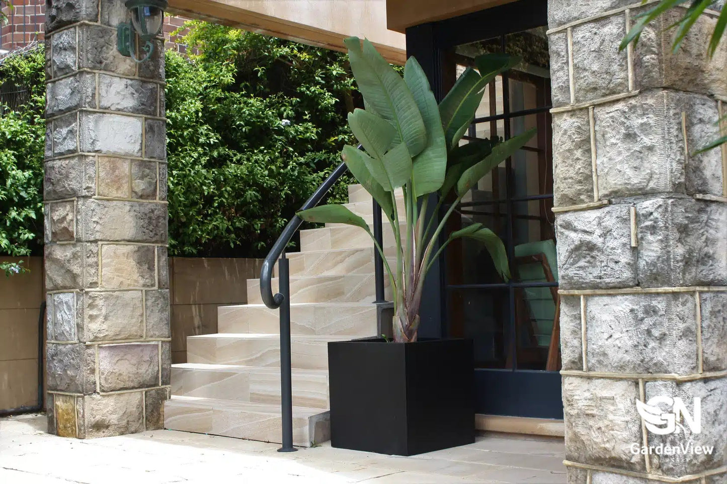 Modern square cube pots in various sizes arranged on a patio with plants, showing clean geometric lines
