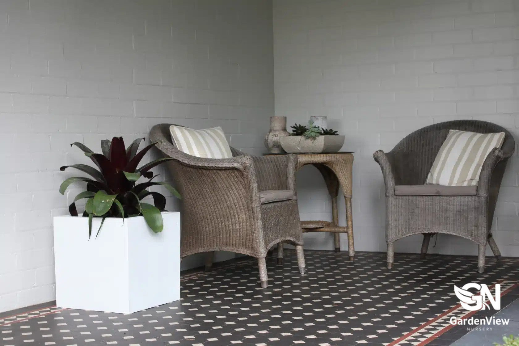 Modern square cube pots in various sizes arranged on a patio with plants, showing clean geometric lines