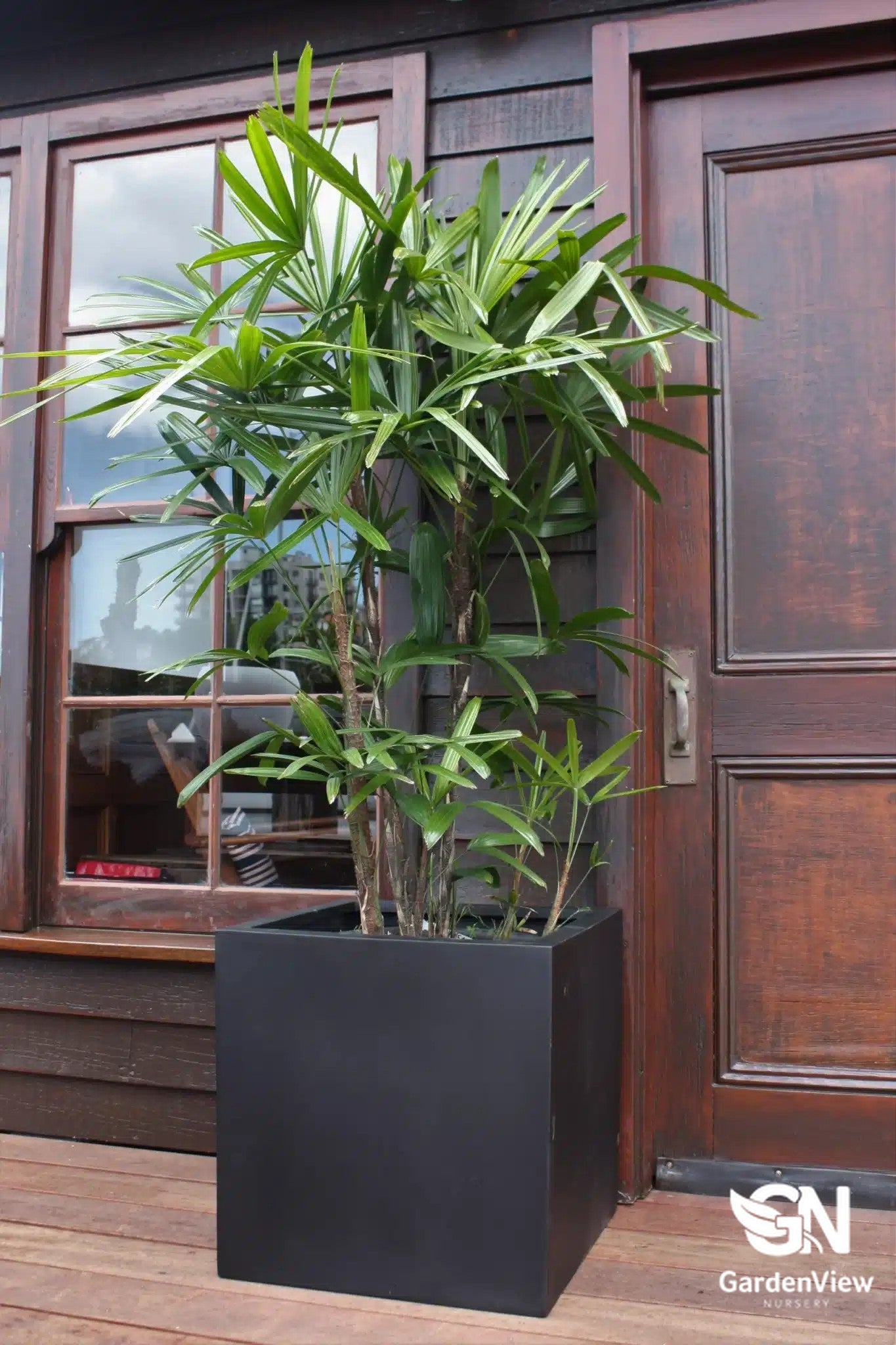 Modern square cube pots in various sizes arranged on a patio with plants, showing clean geometric lines