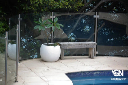Curved dome-shaped ceramic pots in various sizes displaying different plants on a garden bench