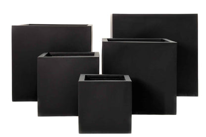 Modern square cube pots in various sizes arranged on a patio with plants, showing clean geometric lines