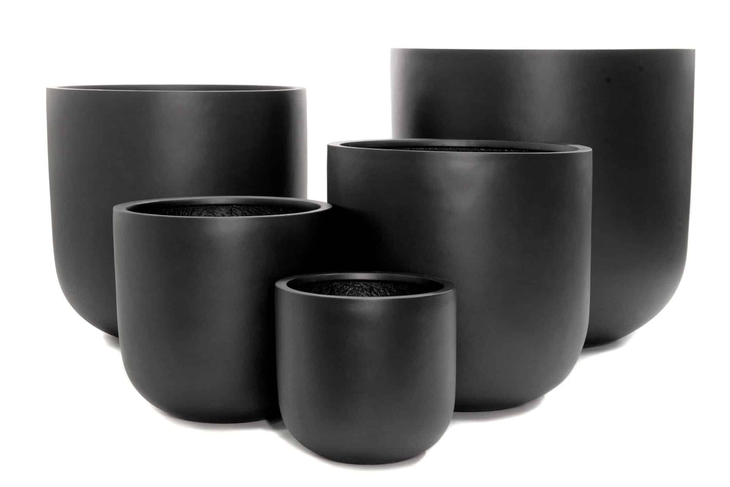 Collection of classic terracotta and ceramic plant pots in various sizes displayed on garden bench