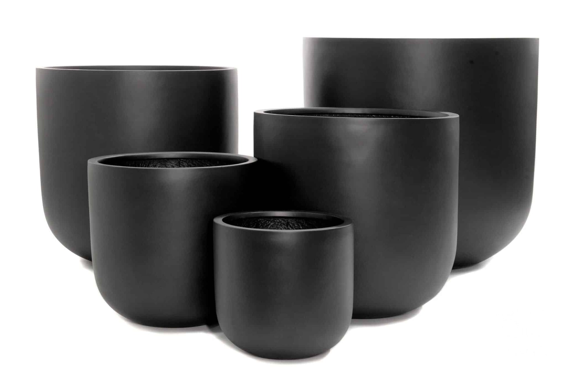 Collection of classic terracotta and ceramic plant pots in various sizes displayed on garden bench