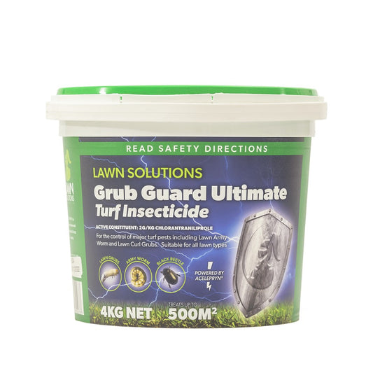 Grub Guard Ultimate pest control bottle on garden bench with healthy green lawn and vegetable garden in background